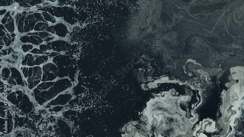 Drone view capturing black wastewater surfaces and oxygen bubbles in an industrial treatment facility, representing biological treatment, water recycling, and advanced waste management technology.

