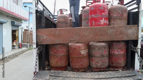 Indian Woman Handling LPG Gas Cylinders in Rural Village, featuring fuel, household, cooking, with the activity clearly visible in the rural setting and natural surroundings.