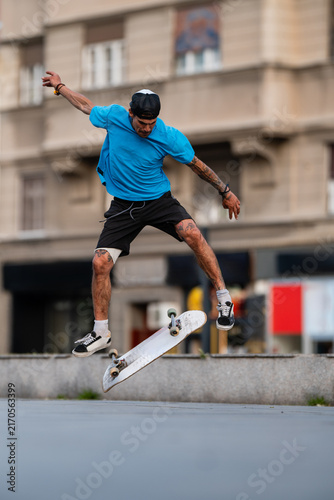 Картината върху платно Skater performing kickflip trick in urban environment