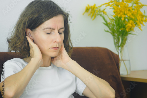 Konstfotografi Close portrait of woman touching neck side behind ear for muscle stiffness easing