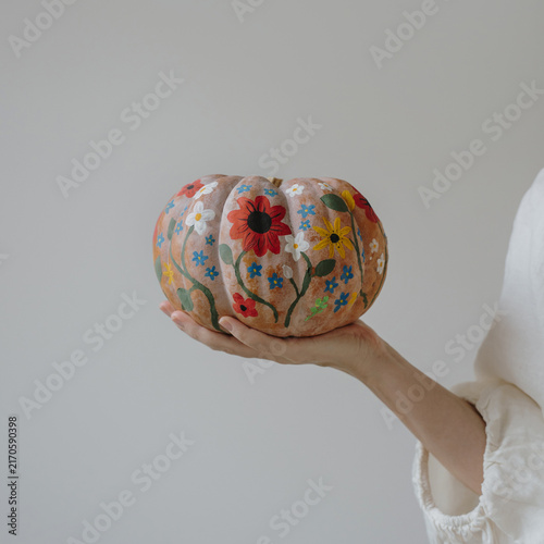 Woman Holding Hand Painted Pumpkin Decorated With Colorful Floral Patterns