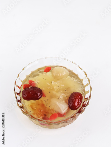 A high-angle studio shot of a traditional Asian sweet dessert soup served in a clear glass bowl against a clean white background.