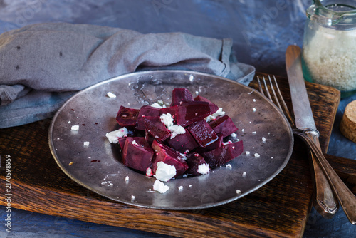 Metal plate of beetroot salad with feta and sea salt