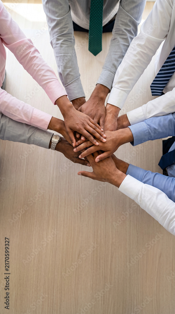 Obraz premium A group of diverse hands stacked together in unity, symbolizing teamwork and collaboration, representative of business success and partnership