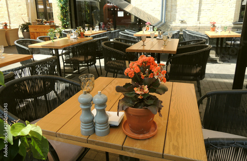 Cozy Restaurant Patio with Tables and Chairs Under Umbrellas at Siesta Time
