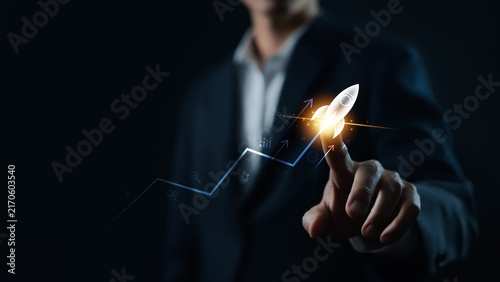 Business growth concept with a professional touching a glowing rocket icon on an upward trend chart, symbolizing startup success, innovation, investment, strategy, and accelerated growth.