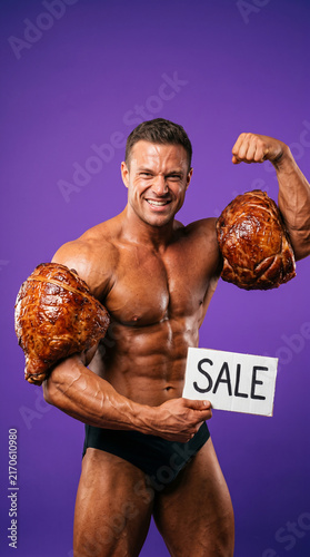 Muscular man flexing with roasted meat, holding a sale sign, signifying strong deals and powerful offers in a promotional context.