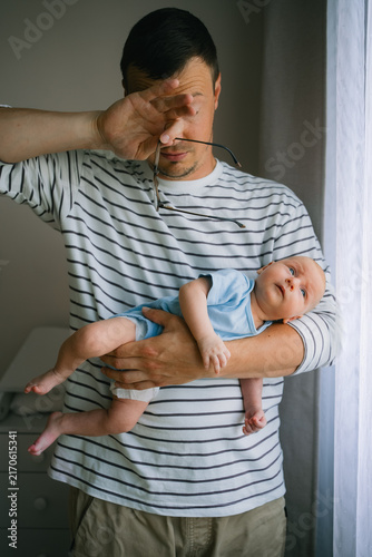 фотографія Tired father experiencing parental stress and exhaustion, rubbing his eyes while