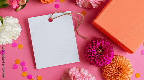 Blank white gift tag with flowers and confetti on pink background, festive flat lay mockup with copy space