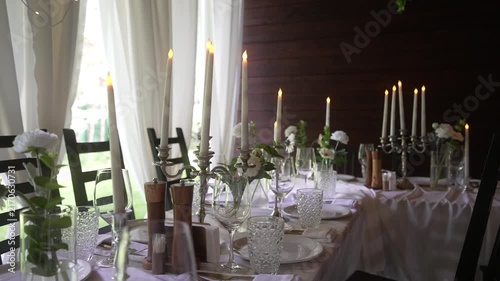 Elegant candlelit dining table with silver candelabra and floral centerpieces in mixed daylight, with candelabra, candle, centerpiece, table detail, showing dining, glassware, crystal, vase