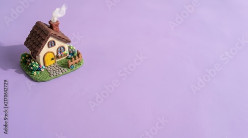 Small miniature house on purple background.