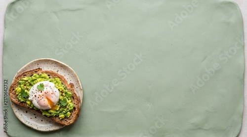 Avocado toast with poached egg on green background.