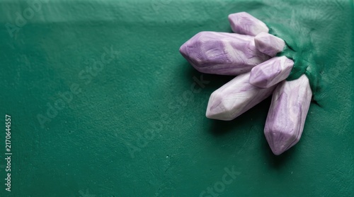 Purple crystal cluster on green clay texture.