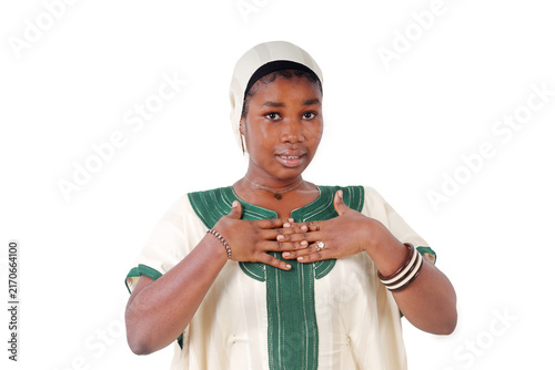 Young African woman with both hands clasped on her chest, a gesture of gratitude, white background
