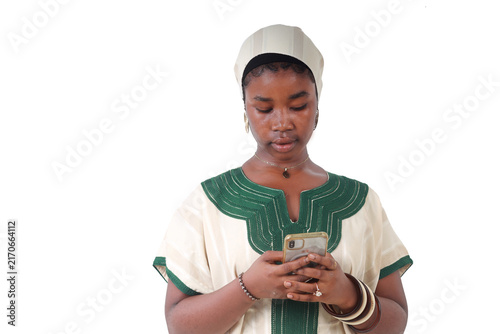Young African woman using her smartphone, traditional dress, white background