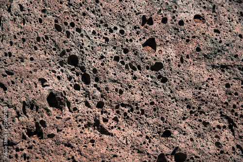 Foto Full frame close-up of porous red volcanic lava rock texture with vesicular holes, resembling Mars terrain, an ideal background for design projects, Teide, Tenerife, Canary Islands, Spain