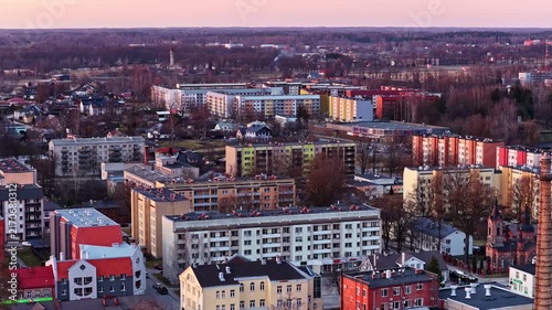 Aerial cityscape view over residential neighborhood of small town in eastern Europe during late afternoon golden hour.