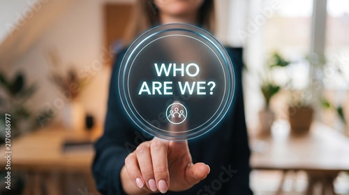 Business professional interacting with a virtual futuristic interface displaying the question who are we.