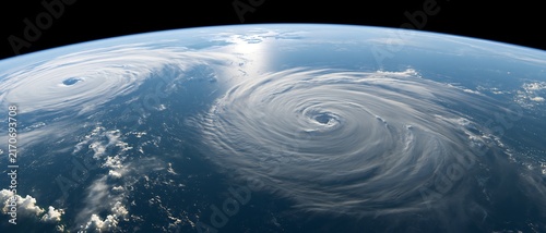 Two tropical cyclones swirling over the ocean viewed from space, illustrating extreme weather, simultaneous storms, climate risk, forecasting and disaster preparedness