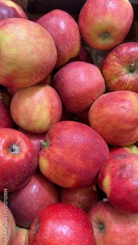 Pile of fresh red and yellow apples in a crate showing natural textures and vibrant colors