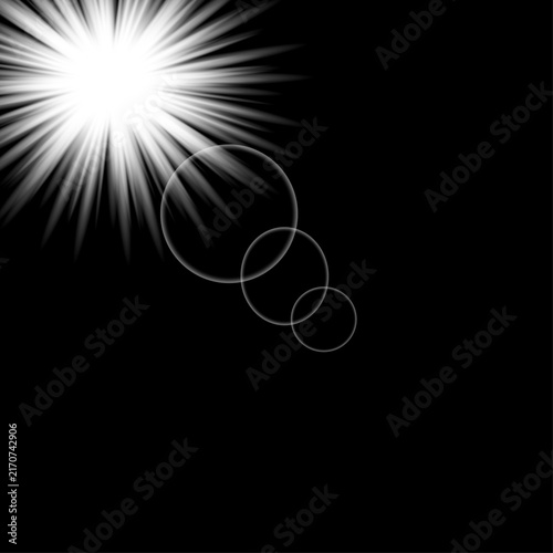 Bright white starburst light effect with lens flare circles on a black background
