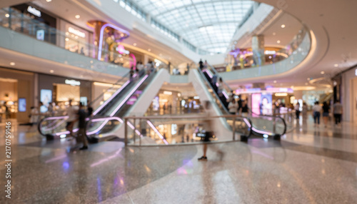 Fully blurred shopping mall background with glowing storefronts, soft architectural reflections, colorful bokeh, and spacious composition for retail advertising, marketing, and graphic design