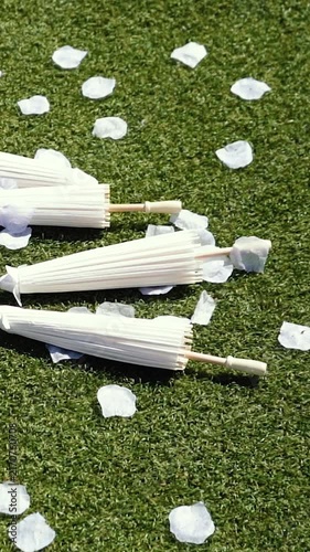 Stylish white vintage umbrellas provide shade from the hot, bright sun on a sunny summer day. Wedding ceremony for the bride and groom.