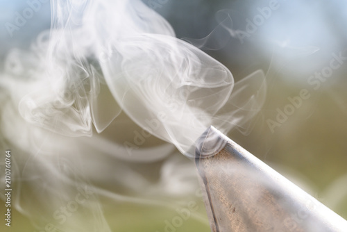 Dense curling smoke from bee smoker close-up
