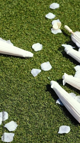 Stylish white vintage umbrellas provide shade from the hot, bright sun on a sunny summer day. Wedding ceremony for the bride and groom.