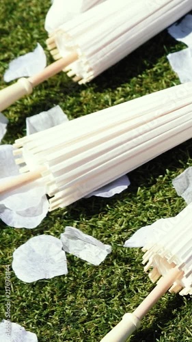 Stylish white vintage umbrellas provide shade from the hot, bright sun on a sunny summer day. Wedding ceremony for the bride and groom.