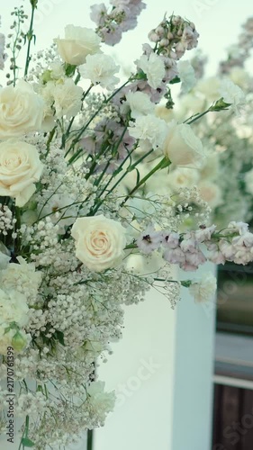 wedding arch of white rose flowers on the river bank before the wedding ceremony of the bride and groom, festive romantic decor