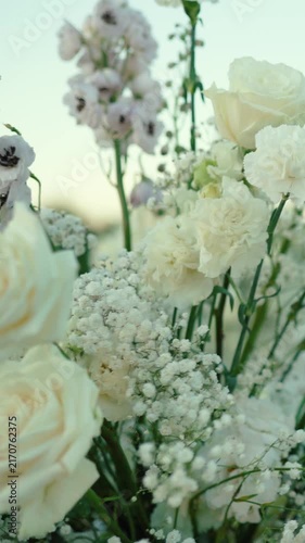 wedding arch of white rose flowers on the river bank before the wedding ceremony of the bride and groom, festive romantic decor