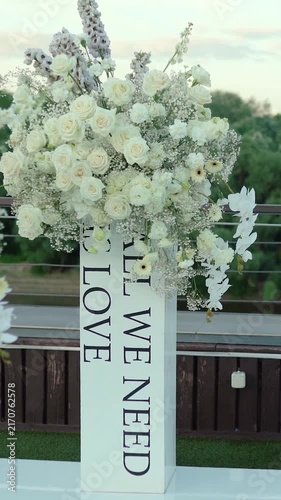 wedding arch of white rose flowers on the river bank before the wedding ceremony of the bride and groom, festive romantic decor