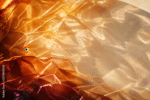 Warm light glows through crinkled, translucent fabric