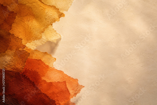 Warm amber tones cascade over soft, textured beige surface