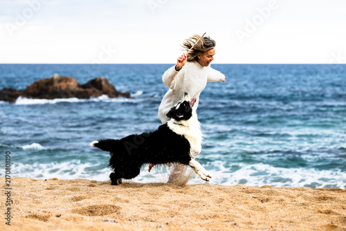 Woman running with her pet on Costa Brava beach in Spain