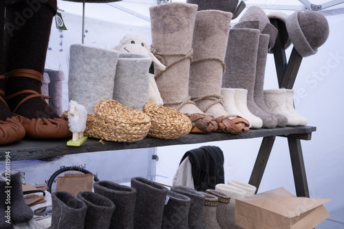 Fotografie Traditional Handmade Felt Boots and Woven Bast Shoes at Market