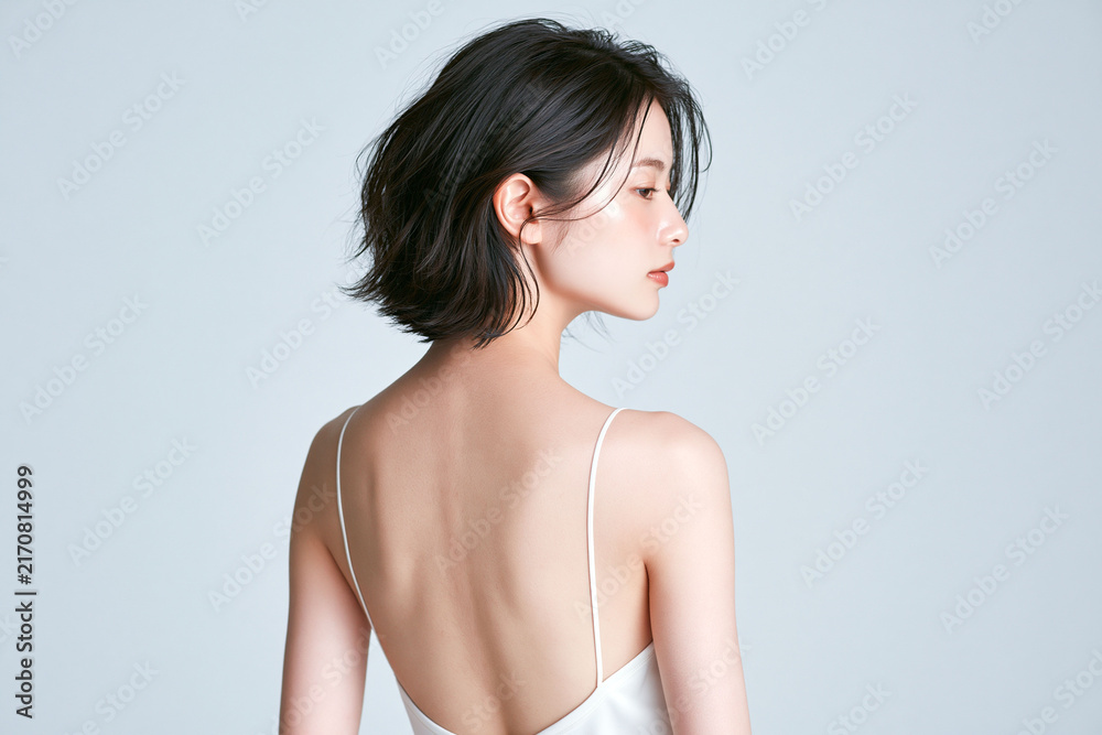 Fototapeta premium 背中を見せる若い日本人女性、なめらかな素肌と肩を強調した美容ポートレート