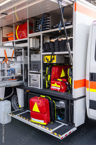 Interior of an ambulance with medical equipment, emergency bags, backpacks, stretchers and storage compartments for first aid supplies and professional healthcare response.