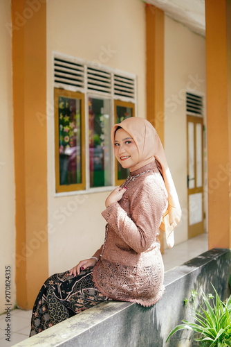 Asian Hijab Woman in Traditional Javanese Kebaya Lace Dress, posing outdoor