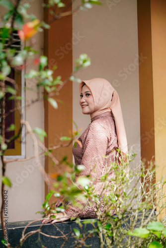 Asian Hijab Woman in Traditional Javanese Kebaya Lace Dress, posing outdoor