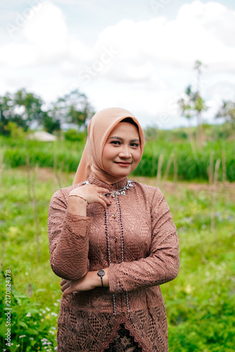 Asian Hijab Woman in Traditional Javanese Kebaya Lace Dress, posing outdoor
