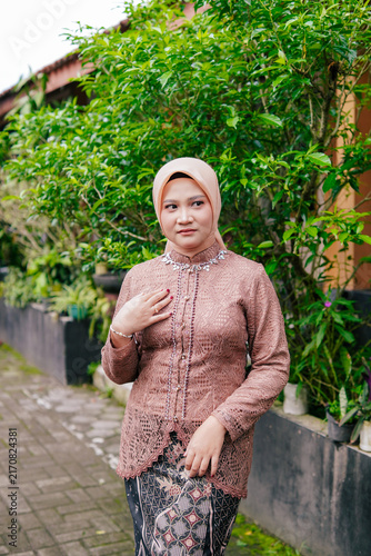 Asian Hijab Woman in Traditional Javanese Kebaya Lace Dress, posing outdoor