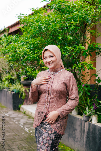 Asian Hijab Woman in Traditional Javanese Kebaya Lace Dress, posing outdoor