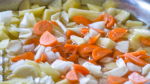 Bild auf Leinwand Chopped fresh vegetables carrots potatoes onion in pot for soup