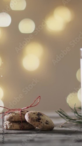 Animation of snowflake christmas decorations, cookies and glass of milk on grey background