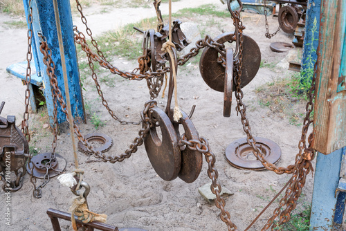 Brutal homemade iron weights and heavy chains hanging on outdoor gym equipment