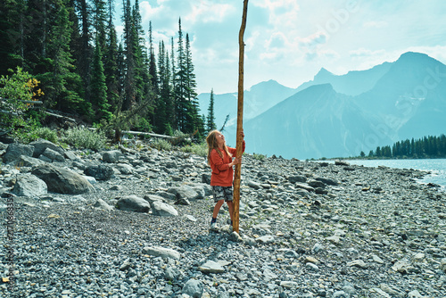 boy holding a very long stick on the beach