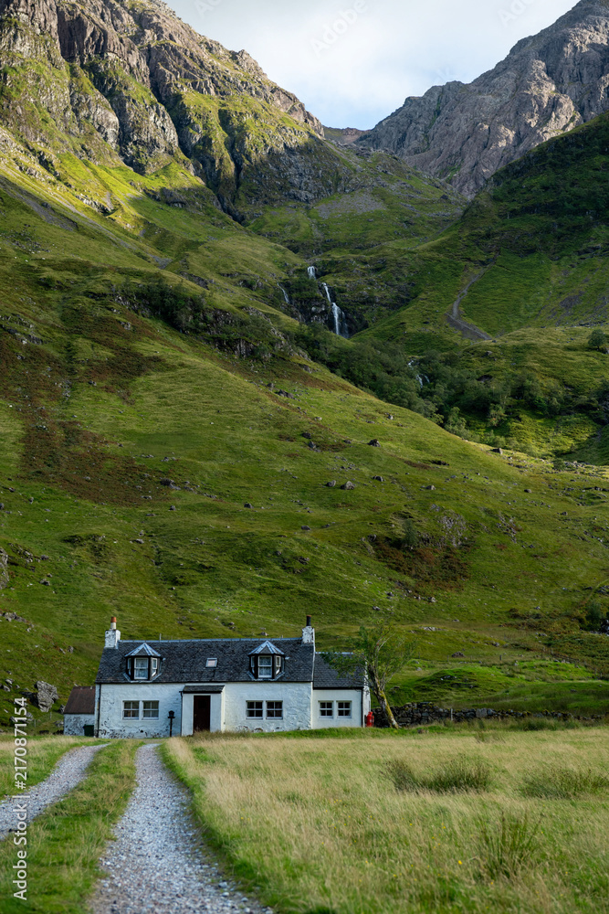 Fototapeta premium Charming cottage amidst lush mountains.