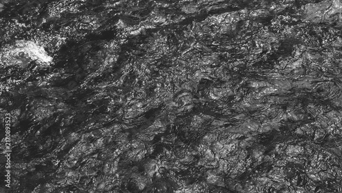 Photography Black and white abstract texture of flowing freshwater, featuring intricate ripples, waves and natural reflections on a rocky stream